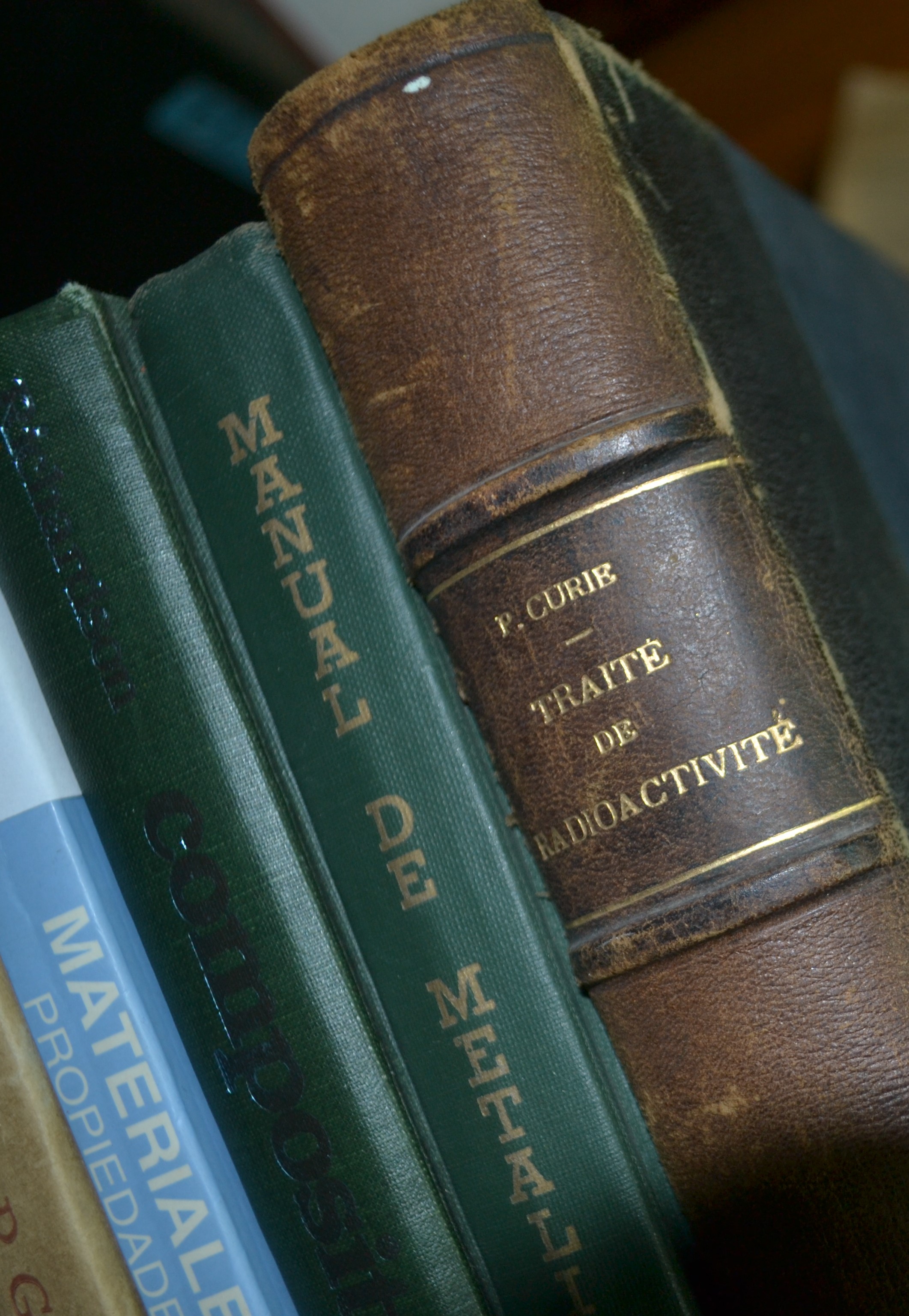 Libros inclinados sobre materiales y uno de ellos es de M. Curie